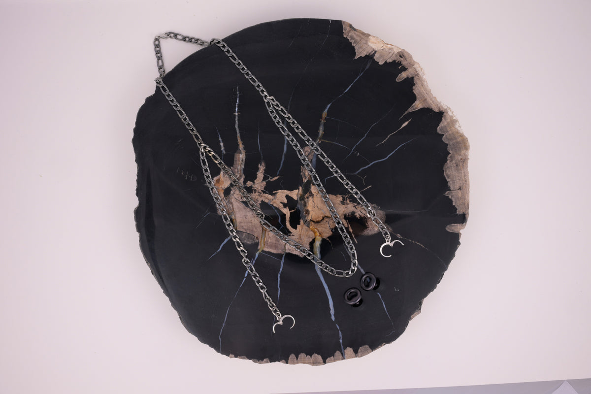 A pair of black ARKS earplugs hanging from their chains.
