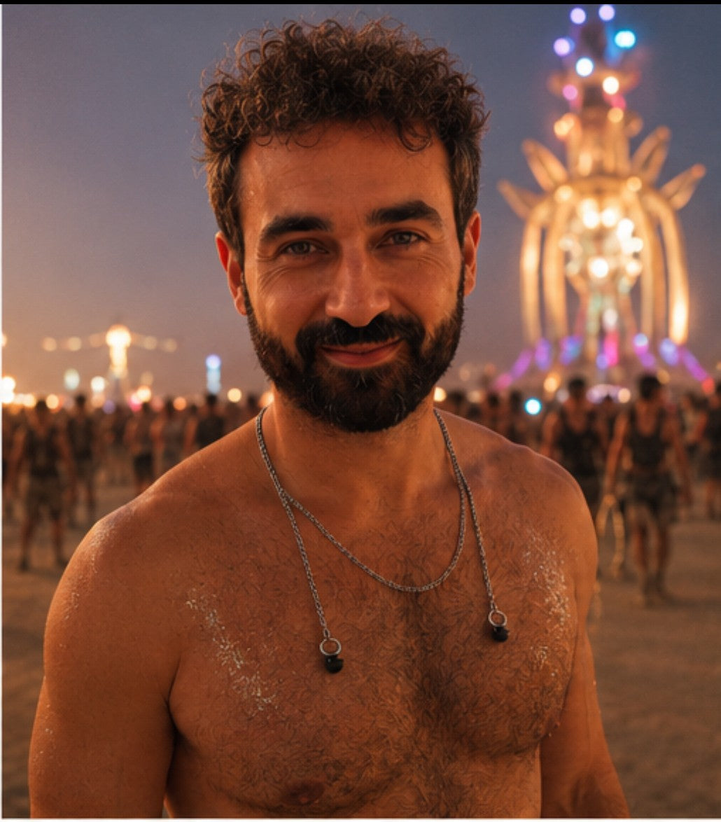 A man at a festival at night wearing the ARKS chain around his neck, earplugs resting on his chest.
